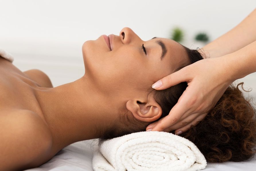 Relaxing Massage. Afro Woman Receiving Head Massage At Spa Salon, Side View