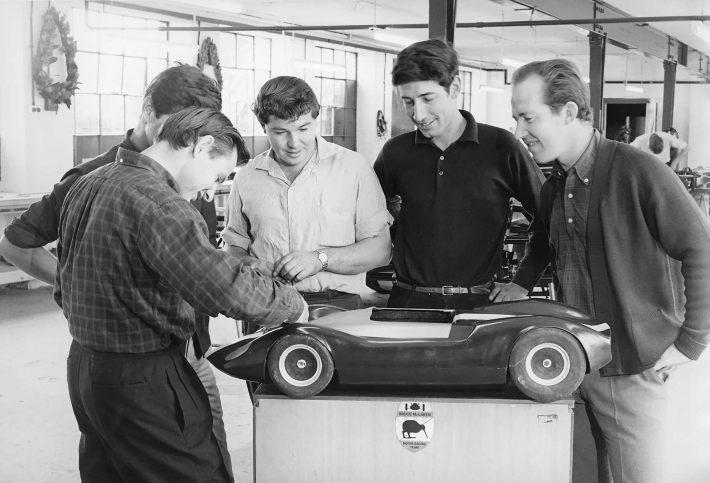Bruce with (hidden) Wally Willmott, Bruce Harre, Howden Ganley, Eoin Young and the model new McLaren Mark 1 - Belvedere Works, Feltham, 1964.