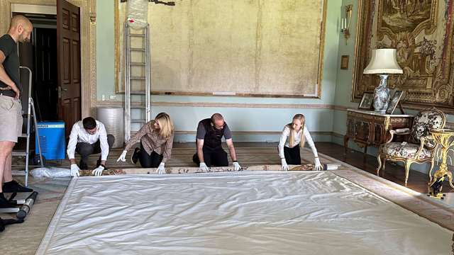 The Salvage Team roll the tapestry up around a support, leaving the damp area exposed so that it dries out. 